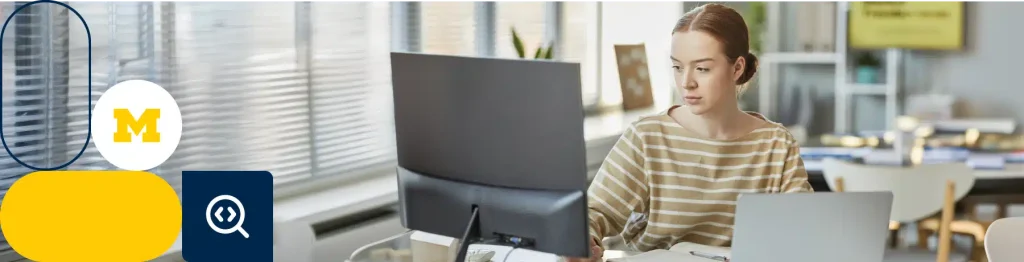 “Person coding on a laptop with University of Michigan logo in the background.”

